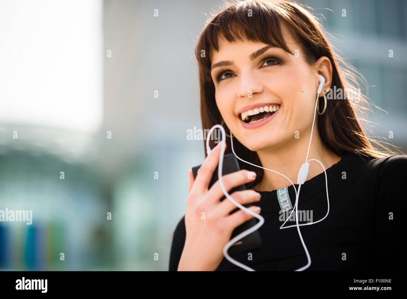 Close up of young woman speaknig en mains-libres de son dans Street Banque D'Images