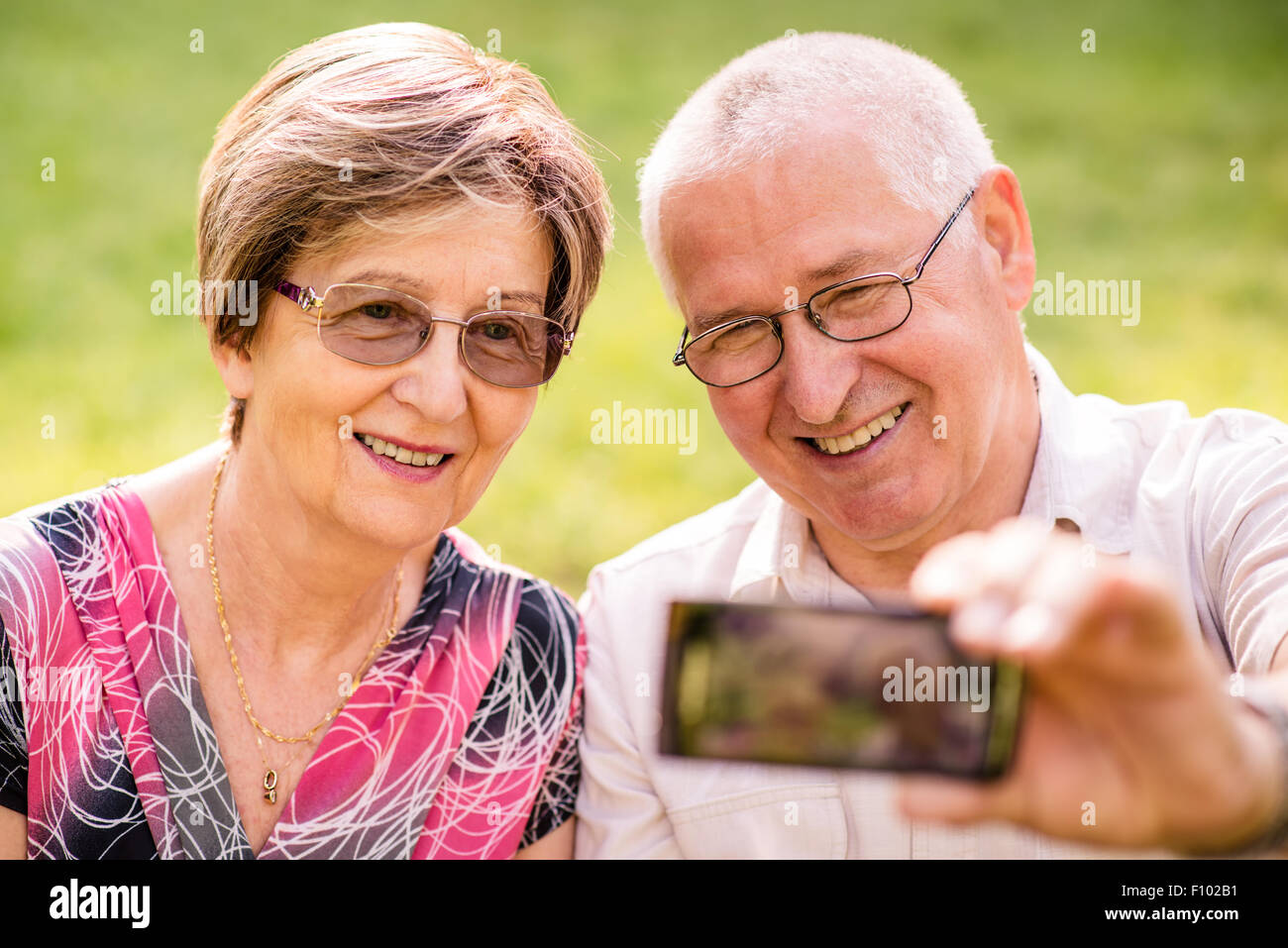 Smiling happy senior couple taking photo d'eux-mêmes par téléphone intelligent Banque D'Images