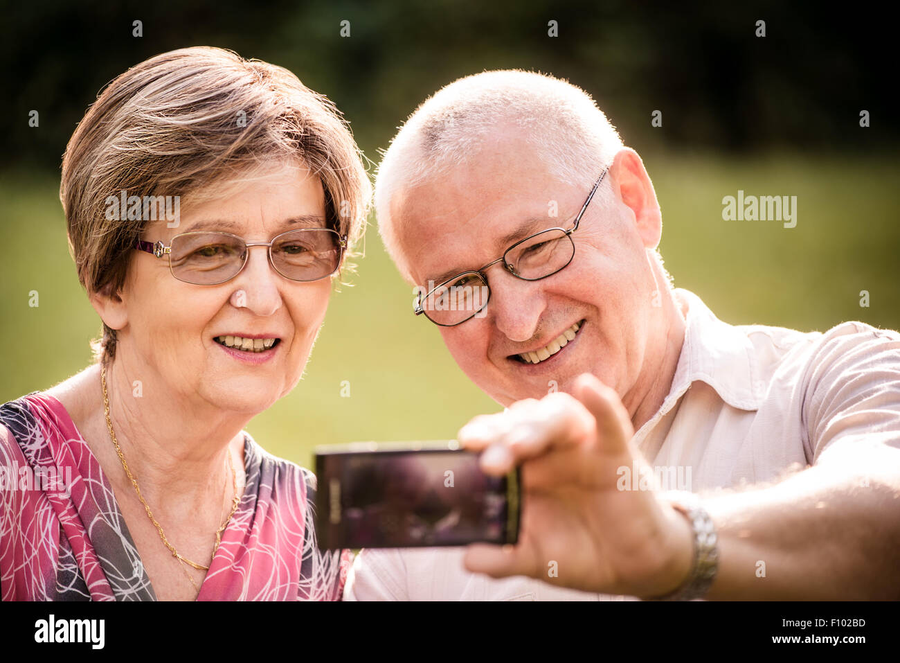 Smiling happy senior couple taking photo d'eux-mêmes par téléphone intelligent Banque D'Images