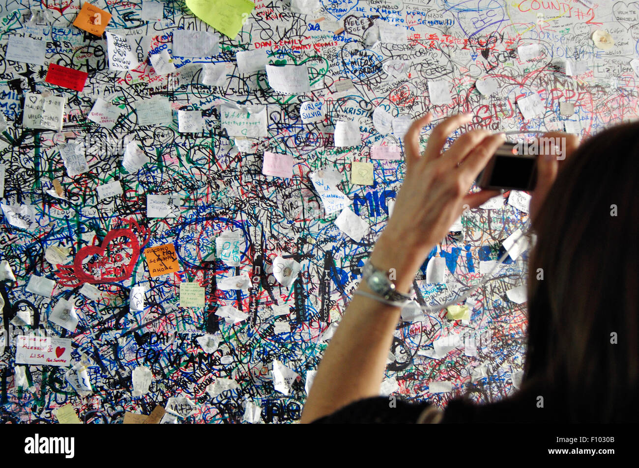 Italie, Vénétie, Vérone, l'amour des notes sur la maison de Juliette, Woman Taking Photo avec l'appareil photo un message d'amour à l'entrée Banque D'Images