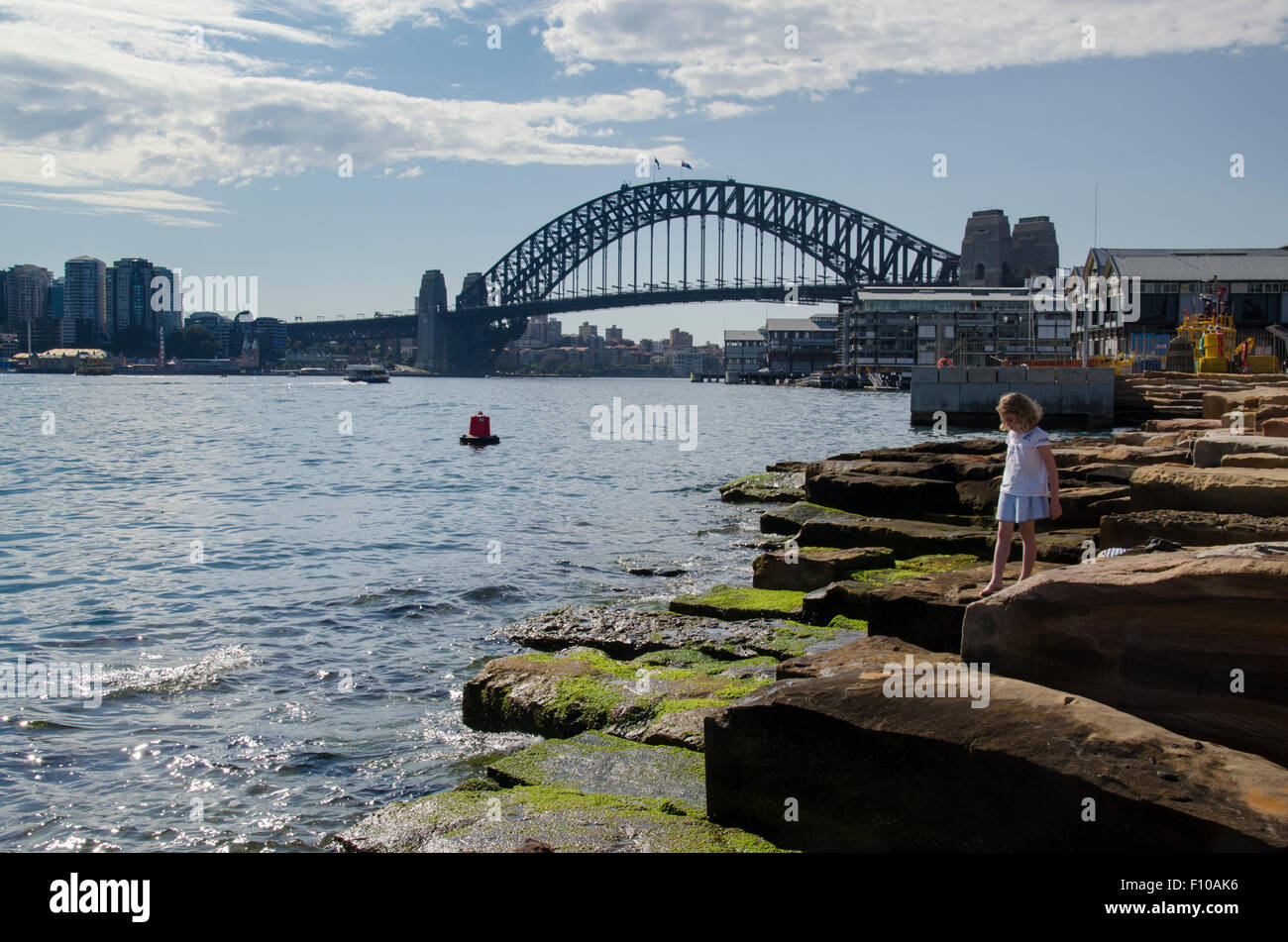 2015 août : un enfant jouant sur quelques-uns des 10,000 blocs de grès taillé sur le site et utilisé sur le bord de l'eau de la réserve de Barangaroo Headland à Sydney Banque D'Images