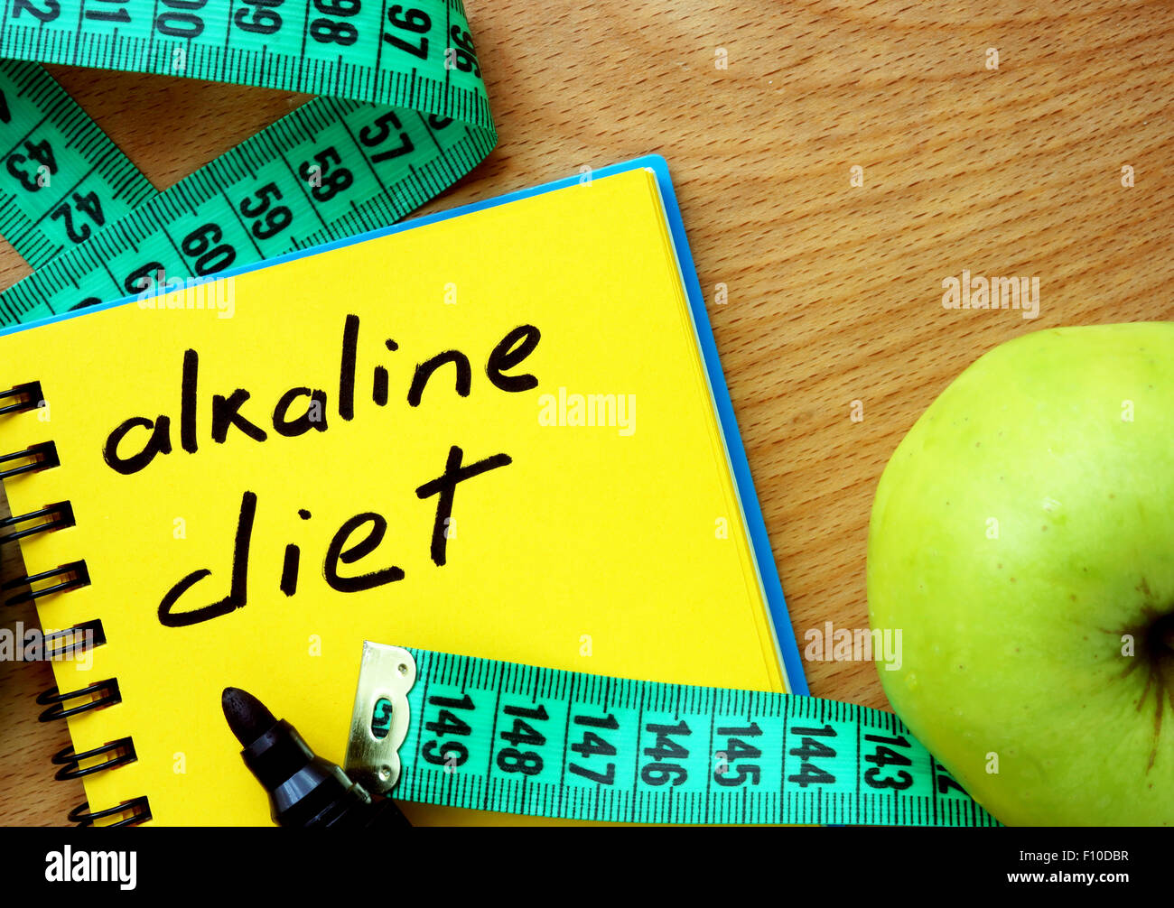 Le bloc-notes avec alimentation alcaline, apple et mesurer tape Banque D'Images