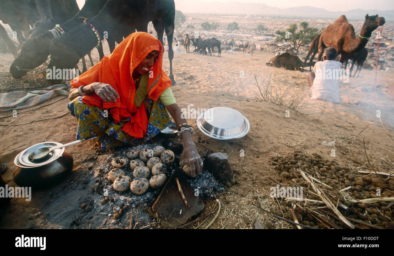 Femme nomade cuisinant des pommes de terre, foire de chameau de Pushkar, Rajasthan, Inde Banque D'Images