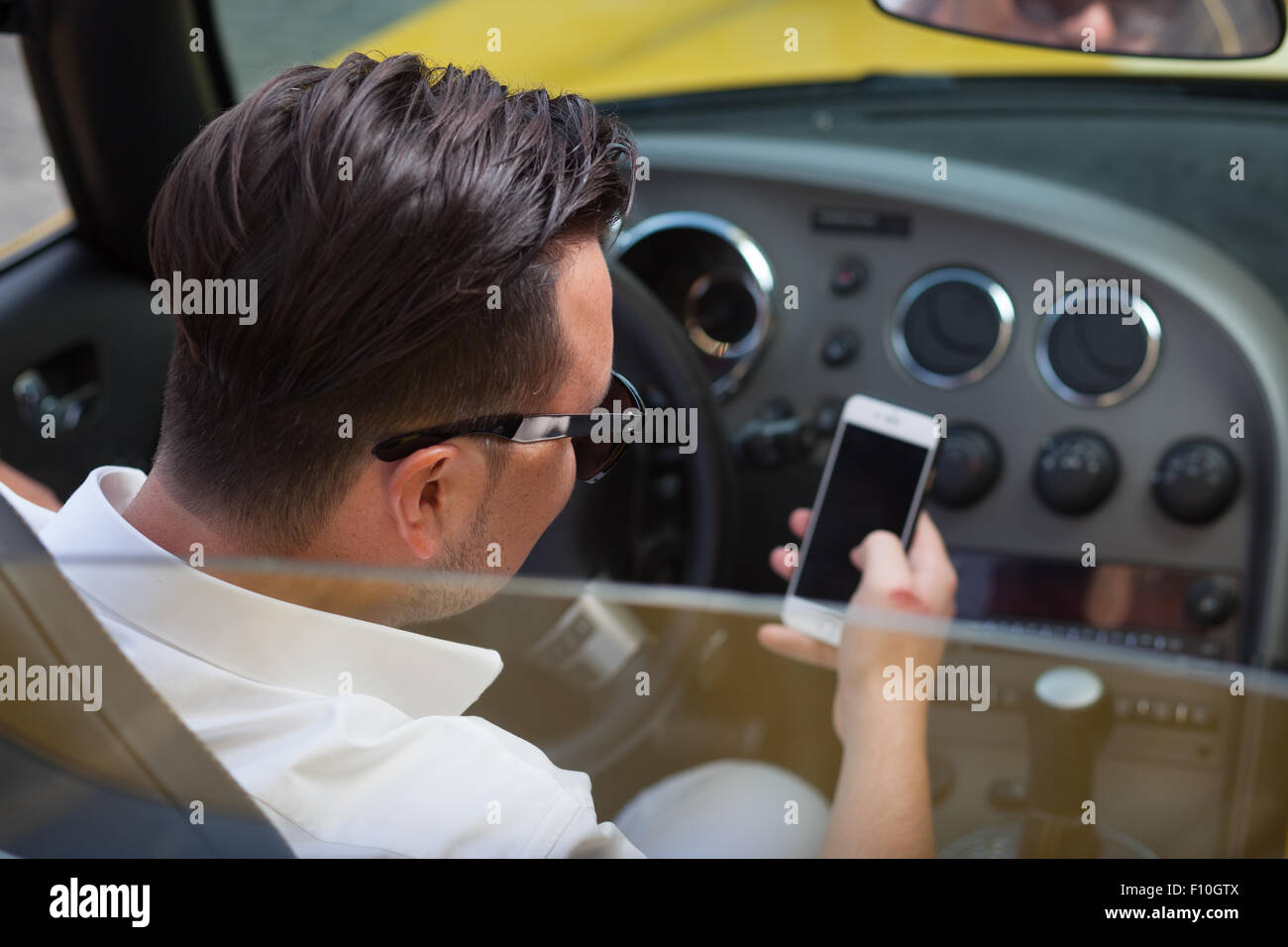 Chauffeur man using smartphone in car Banque D'Images