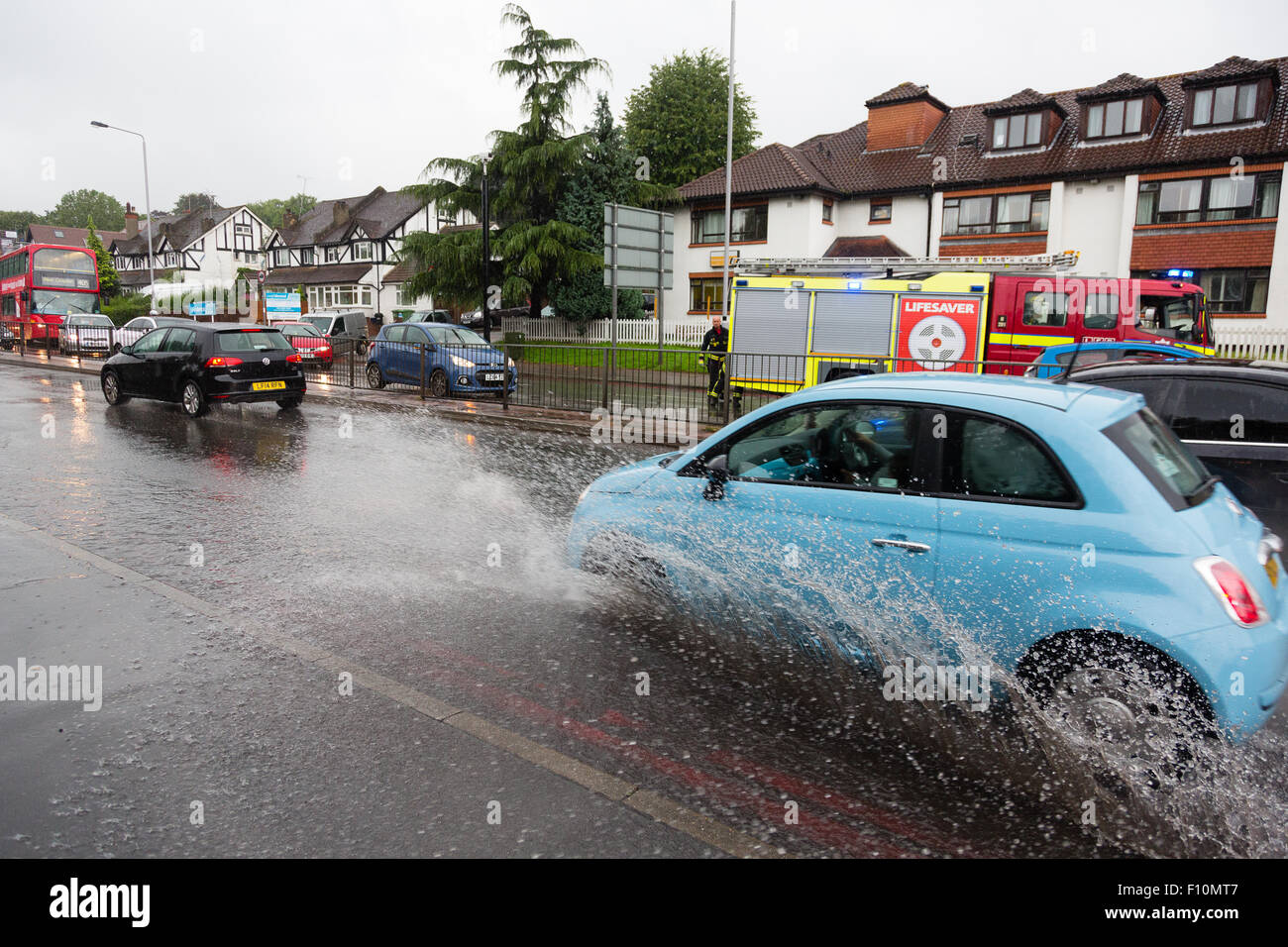 Purley, Londres, Royaume-Uni, 24 août 2015. Splash voitures à travers l'article l'eau d'inondation à Purley, tandis que les pompiers travaillent sur un drain. Une procédure d'alerte jaune pour Londres a été émis par le Met Office. Une quinzaine de jours de pluie est prévu pour l'automne en 24 heures. Crédit : Dave Stevenson/Alamy Live News Banque D'Images