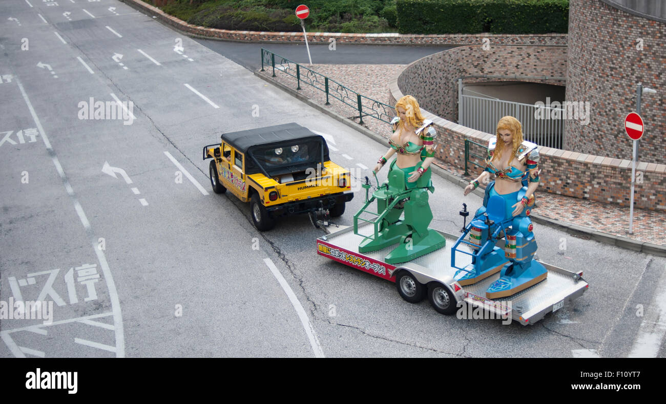 Luttant contre les robots remorqué par un Hummer à visiter les rues de Shinjuku, Tokyo, Japon. Banque D'Images