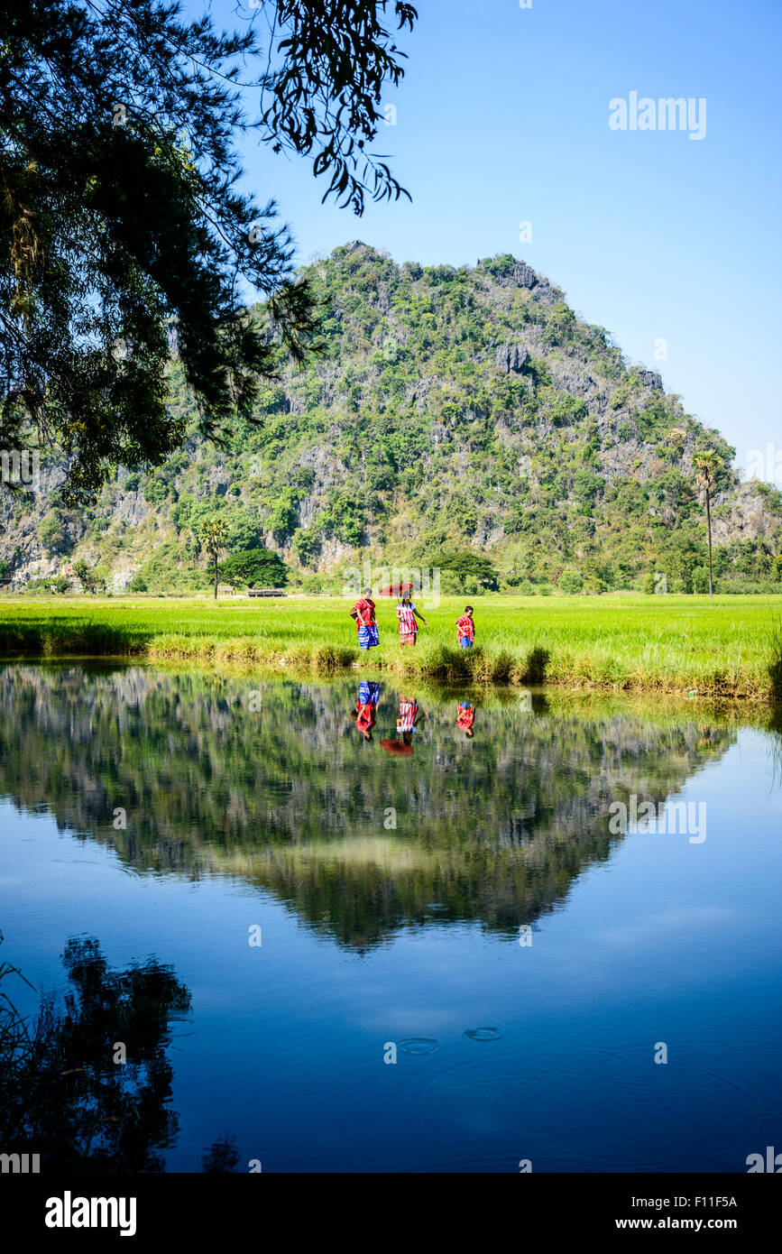 Asian family walking past lake in rural field Banque D'Images