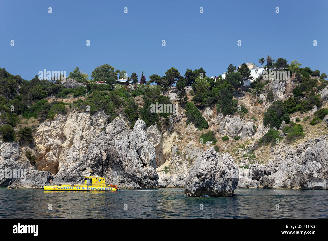Falaises et un bateau à fond de verre, monastère de Panagia Theotokos tis Paleokastritsas ci-dessus, sur les roches, Paleokastrista, île de Corfou Banque D'Images