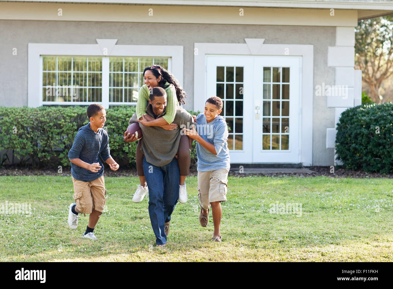 Family playing football in backyard Banque D'Images
