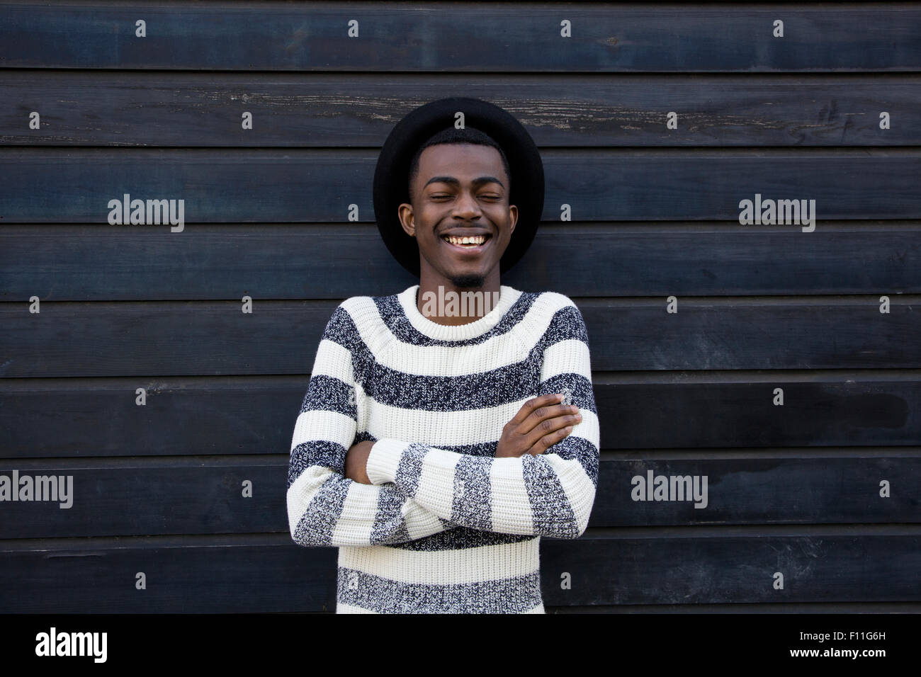Black man laughing près de mur en bois Banque D'Images