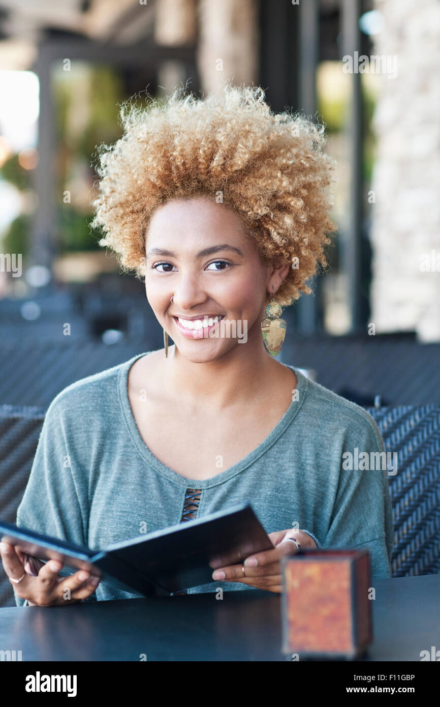 Black woman reading menu at cafe Banque D'Images