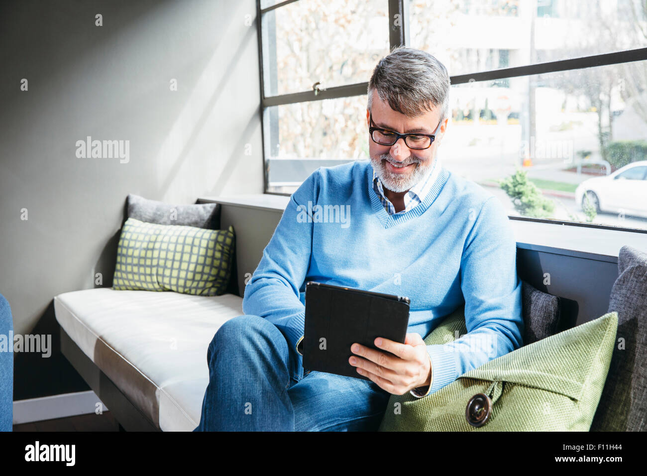 Caucasian businessman using digital tablet in office lobby Banque D'Images