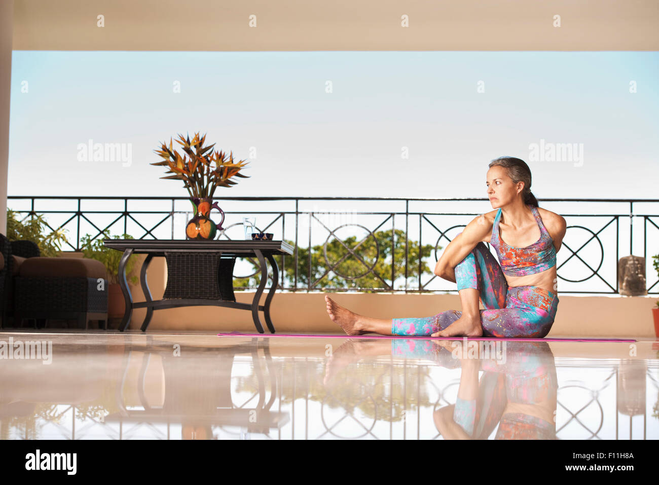Hispanic woman practicing yoga on balcon Banque D'Images