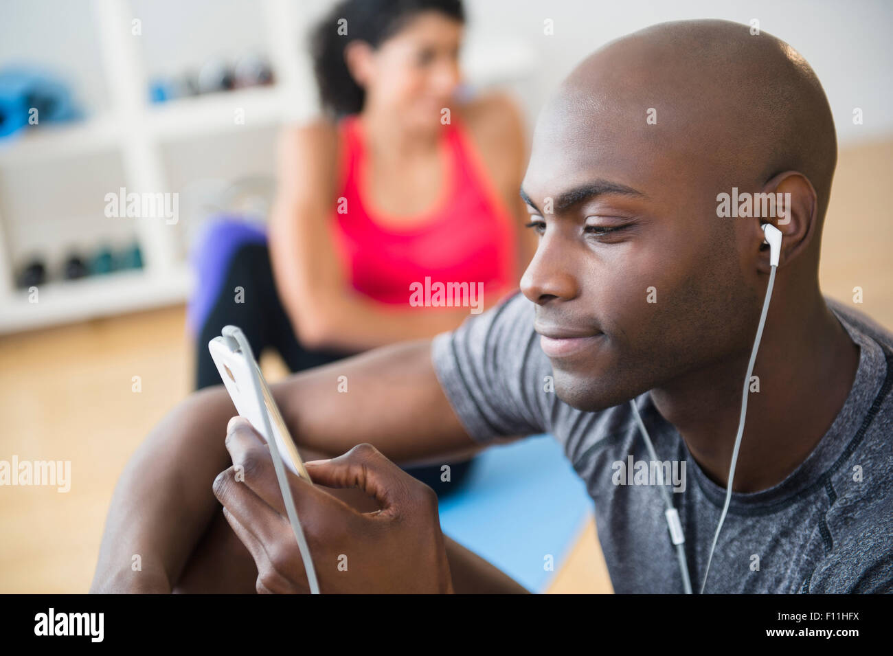 Man listening to earphones in gym Banque D'Images