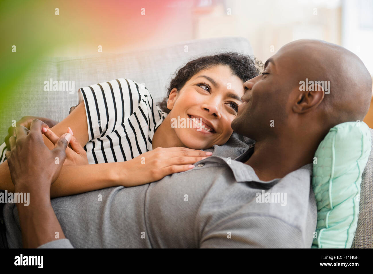 Smiling couple laying on sofa Banque D'Images