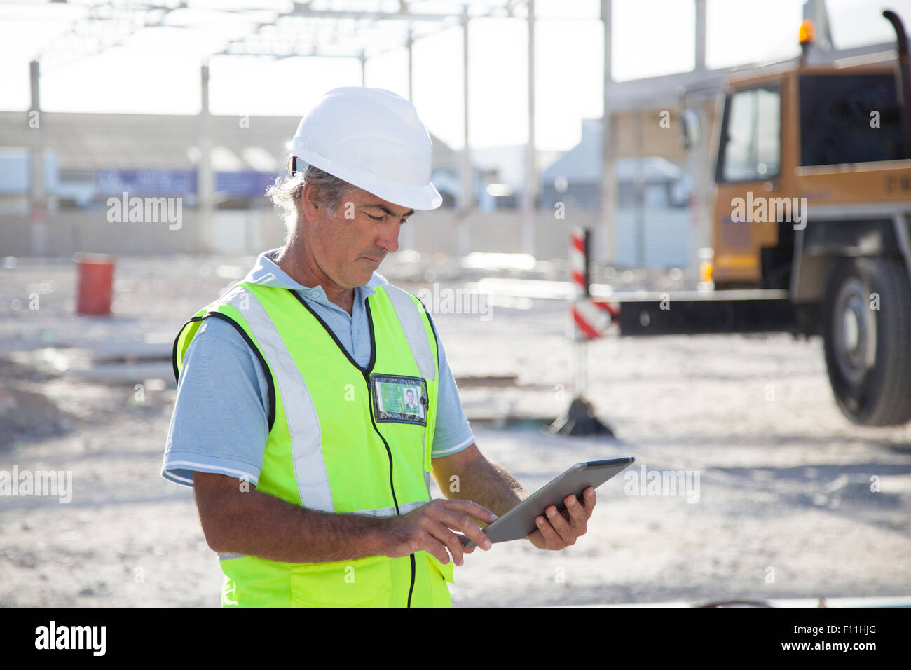 Young construction worker using digital tablet at construction site Banque D'Images