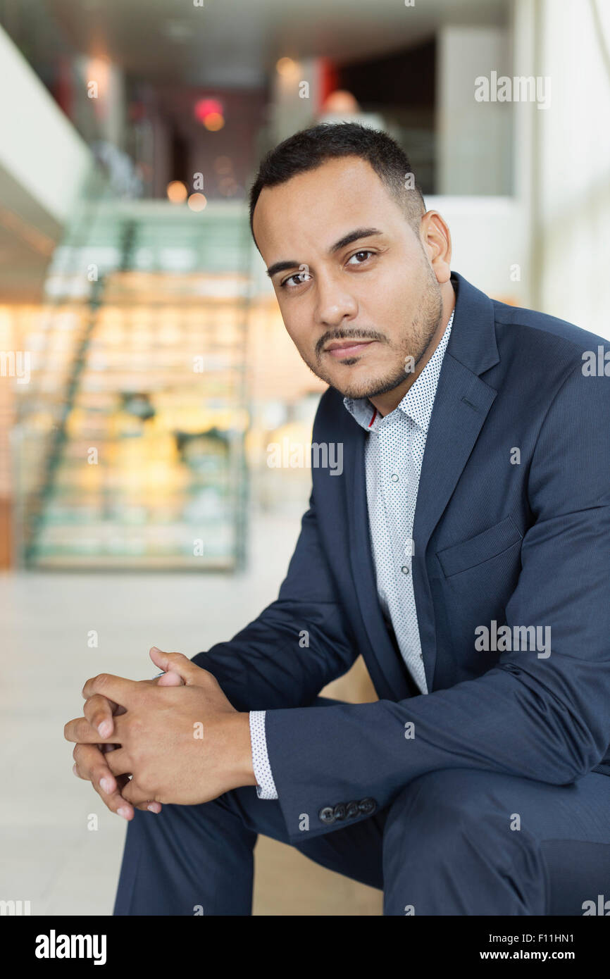 Hispanic businessman sitting in hotel lobby Banque D'Images