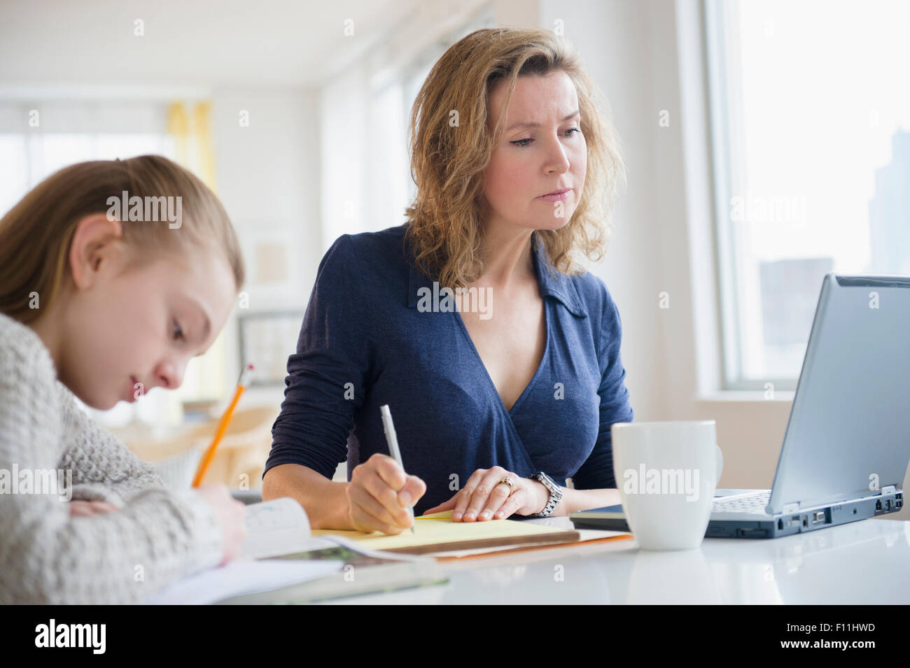 Caucasian mother and daughter working at desk Banque D'Images