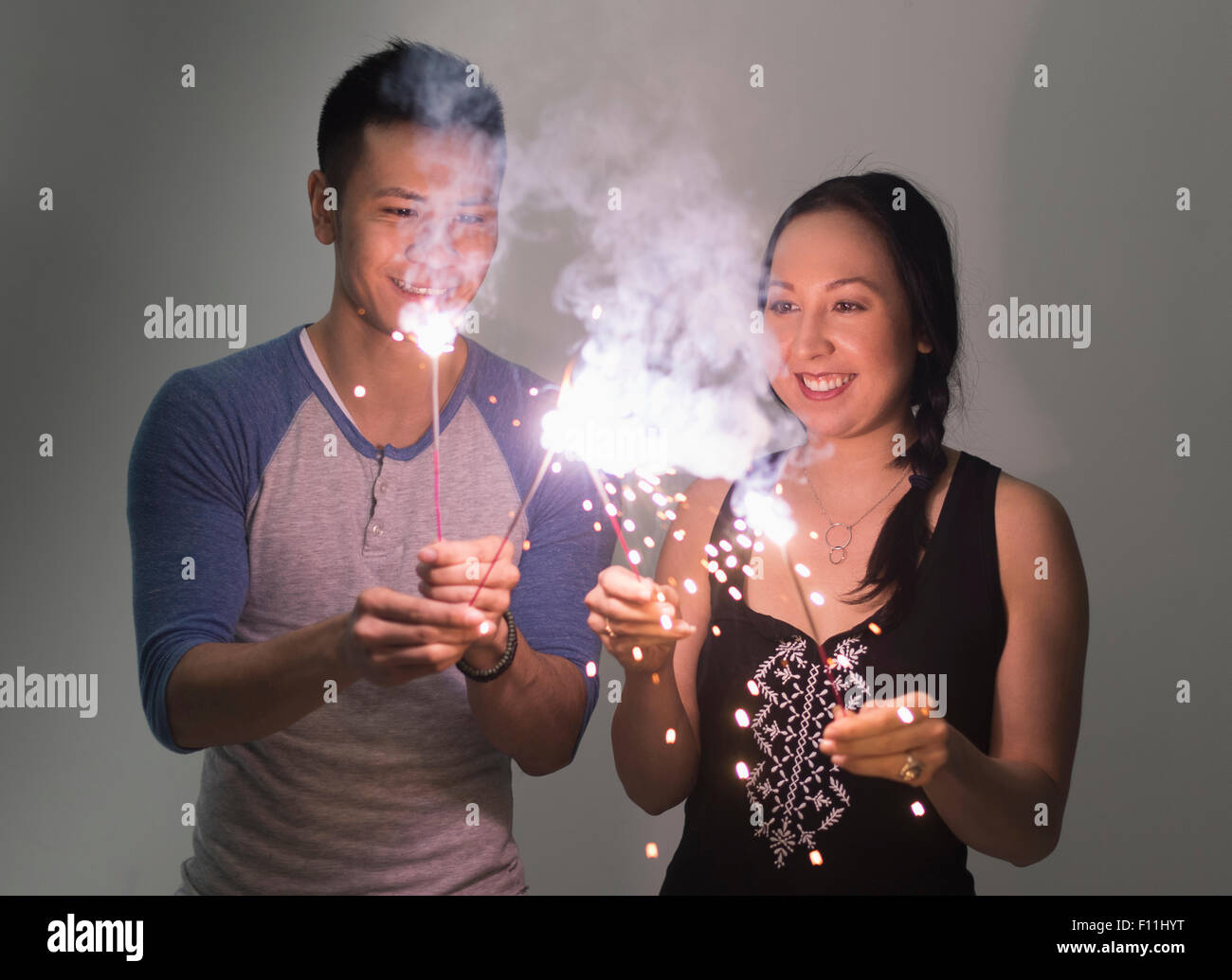 Smiling couple jouant avec les cierges magiques Banque D'Images