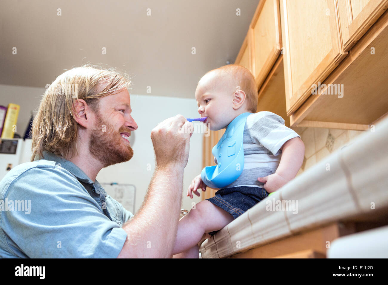 Portrait père fils d'alimentation sur le comptoir de la cuisine Banque D'Images