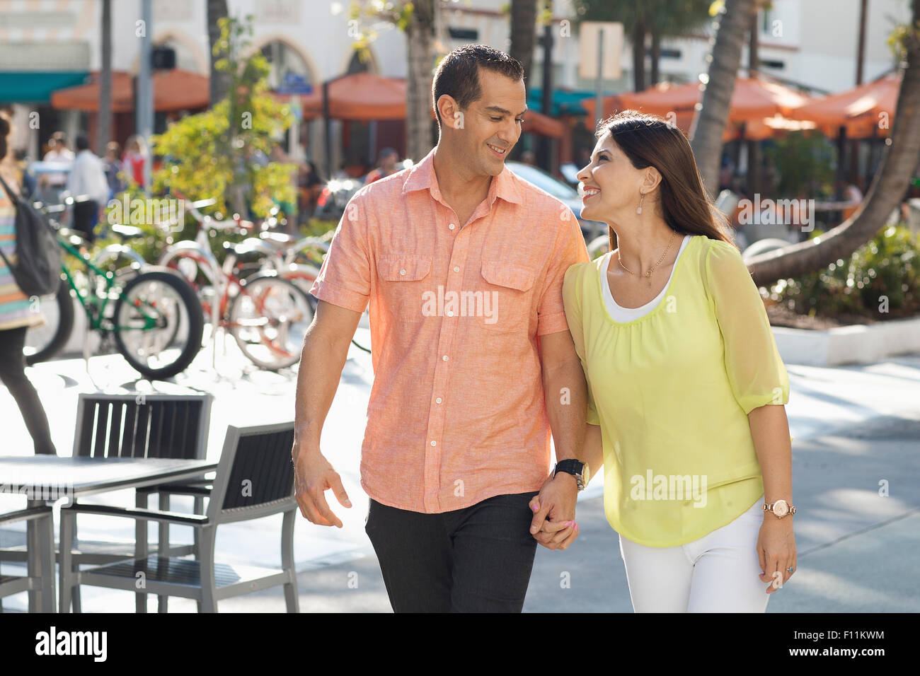 Hispanic couple holding hands on sidewalk Banque D'Images