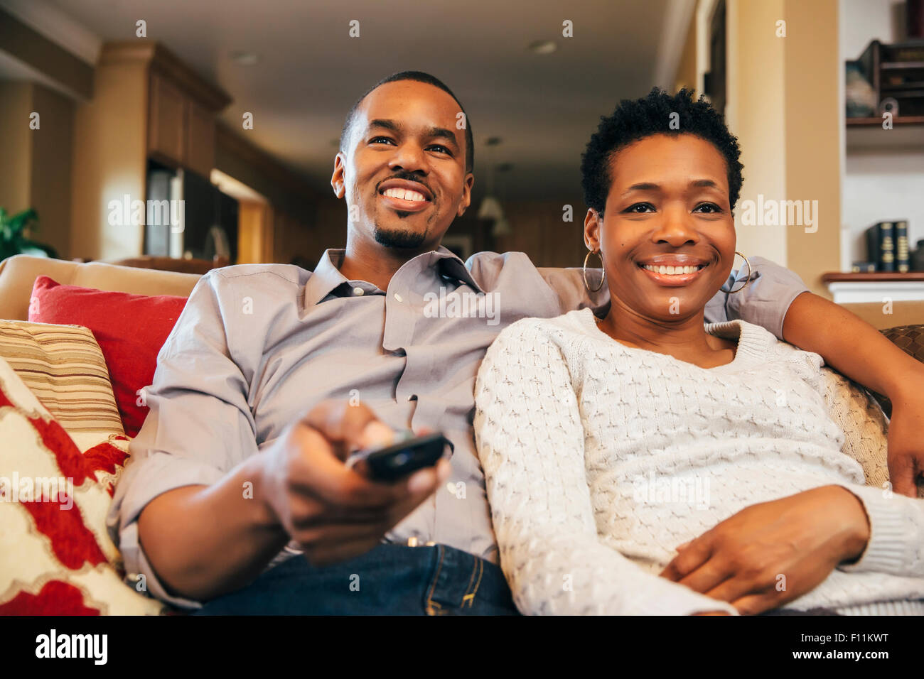 Black couple watching television on sofa Photo Stock - Alamy