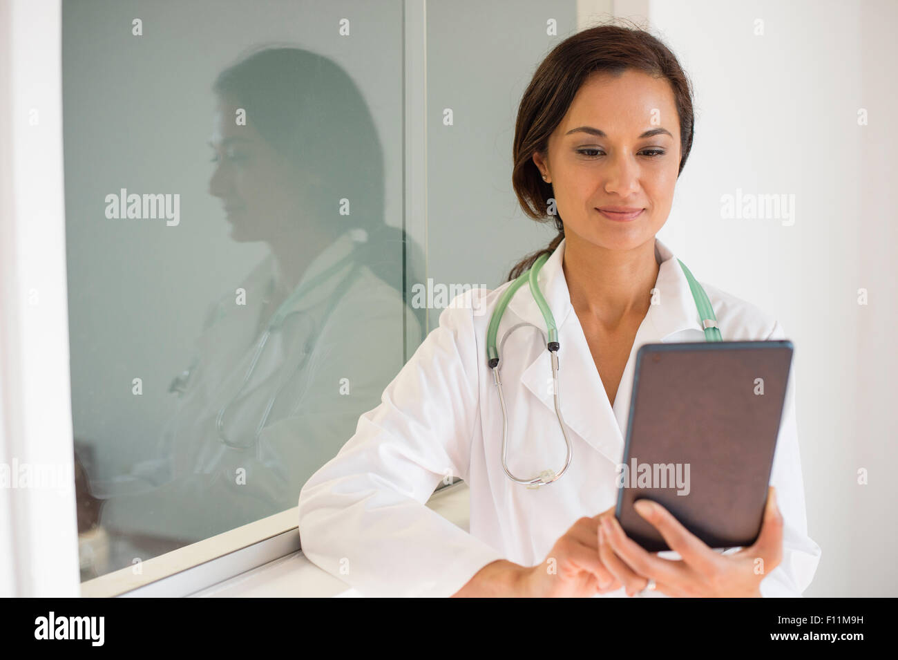 Mixed Race doctor using digital tablet Banque D'Images
