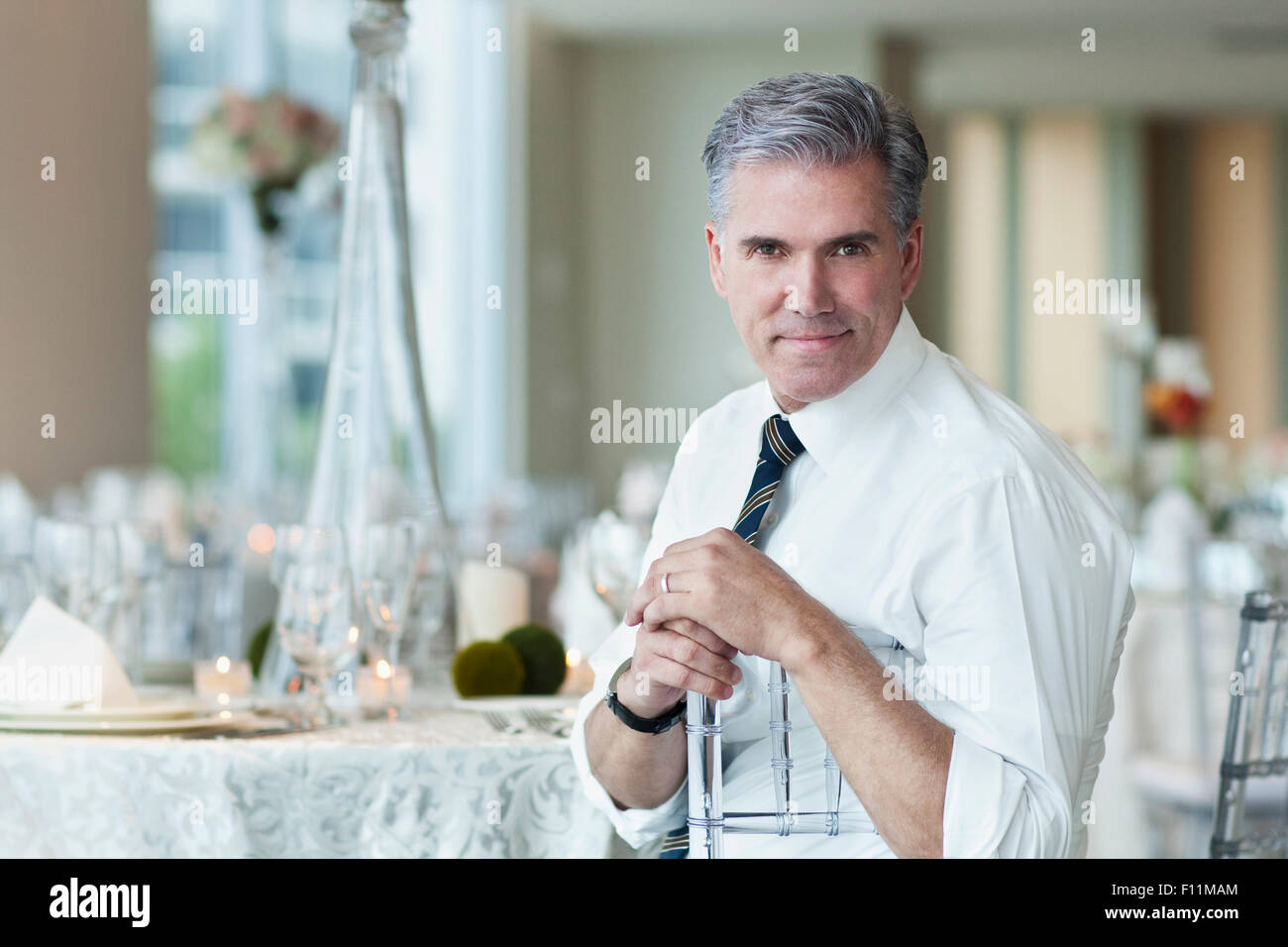 Caucasian businessman smiling in salle à manger vide Banque D'Images
