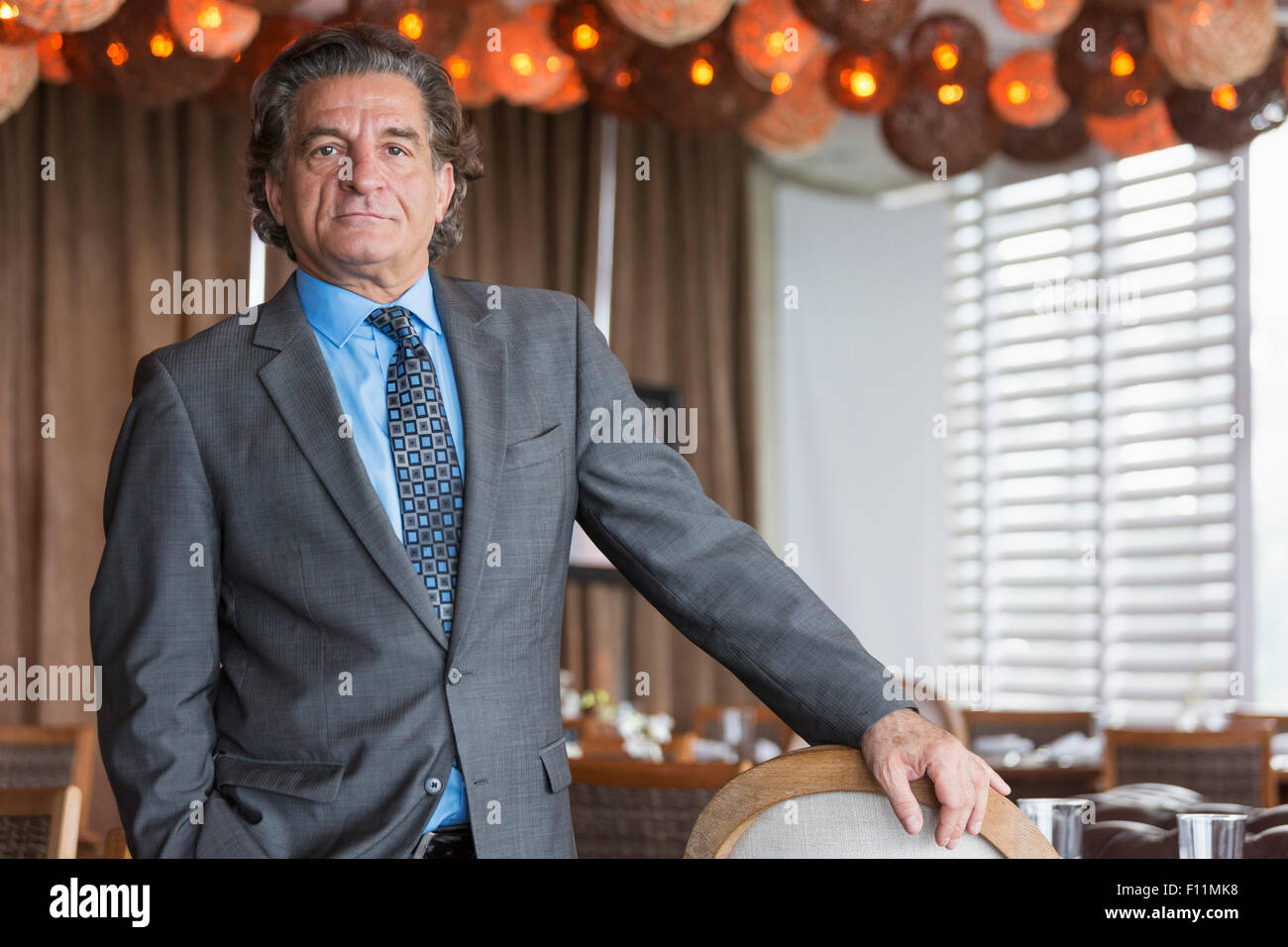 Businessman standing in dining room Banque D'Images