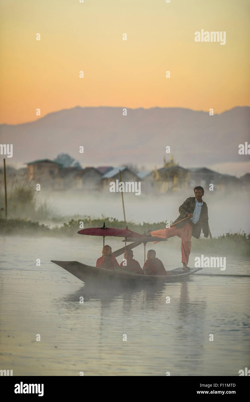 Les moines d'aviron asiatique gondolier en canoë sur river Banque D'Images