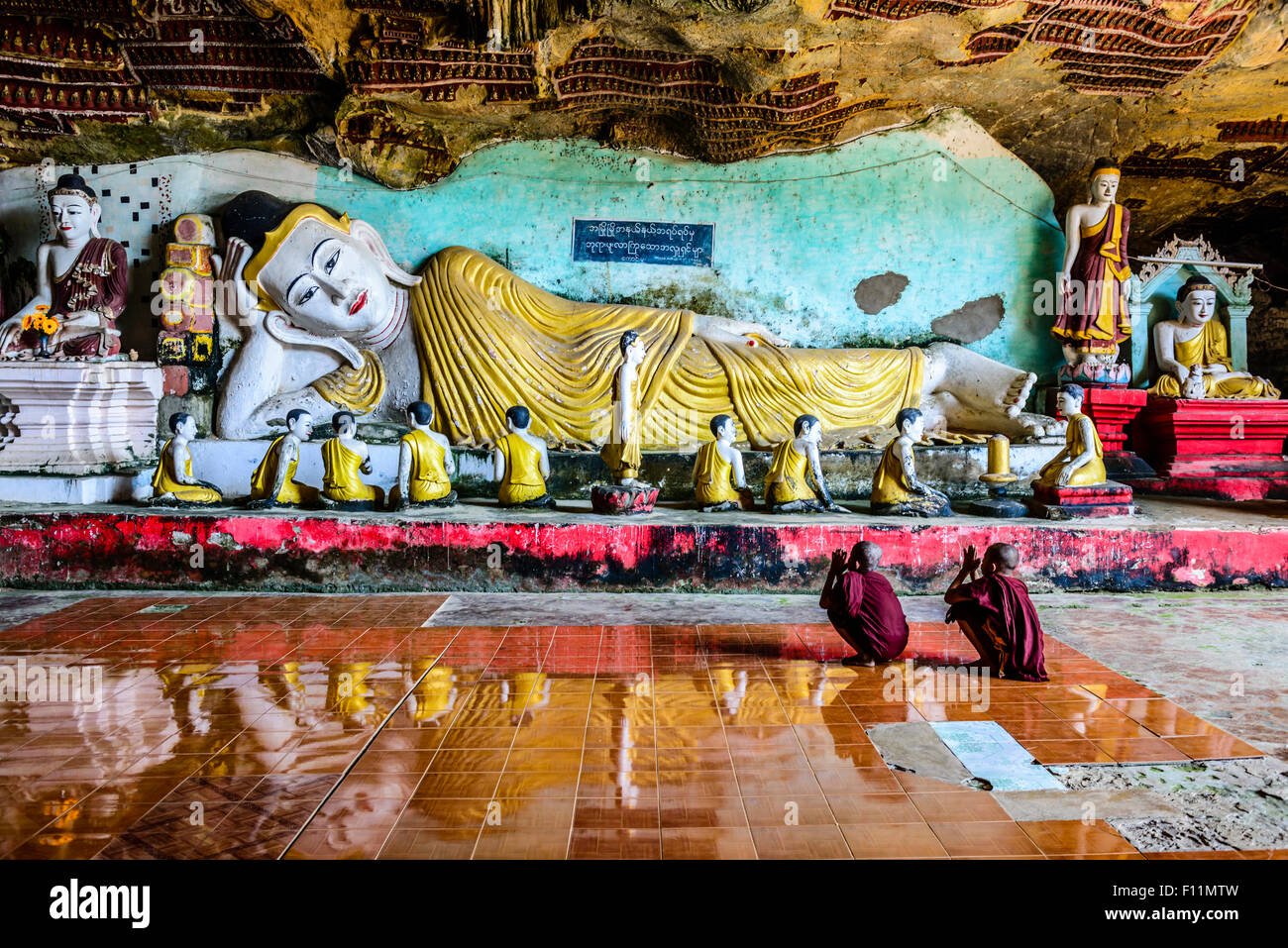 Les moines asiatiques priant à statue de Bouddha de Temple Banque D'Images