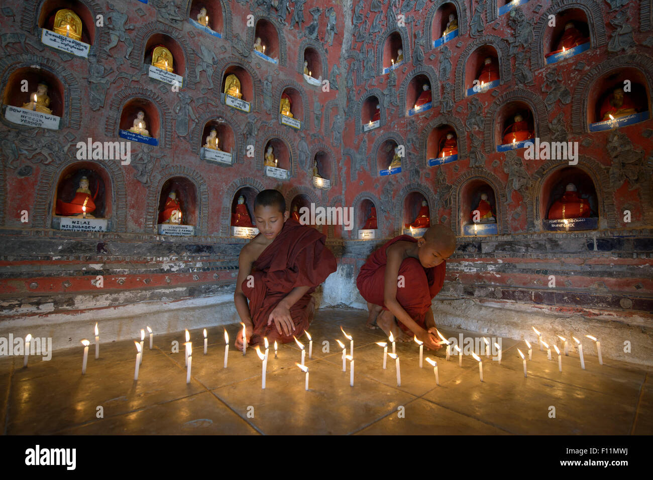 Les moines d'Asie en formation en allumant des bougies ancien temple Banque D'Images