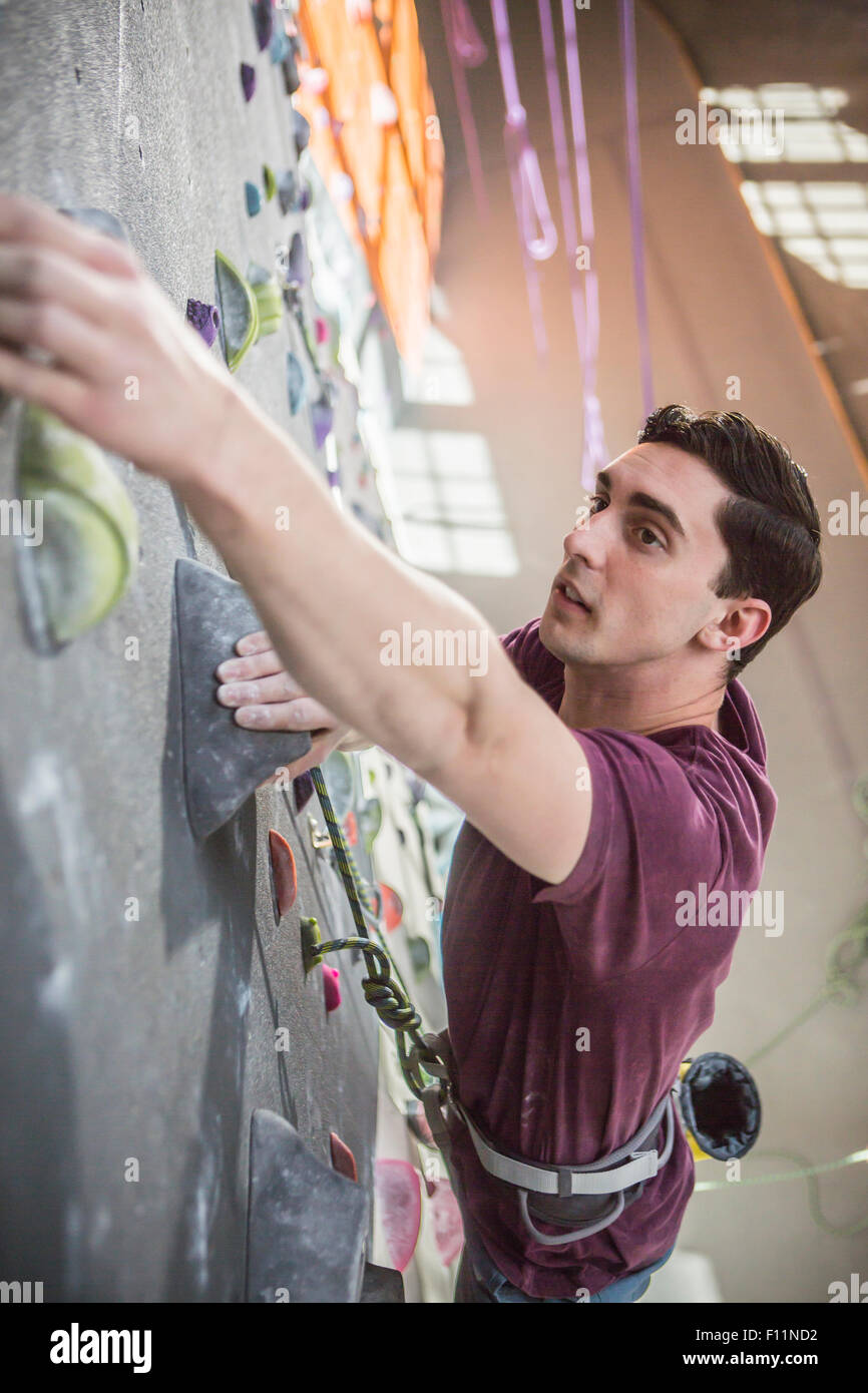 L'athlète de climbing rock wall in gym Banque D'Images
