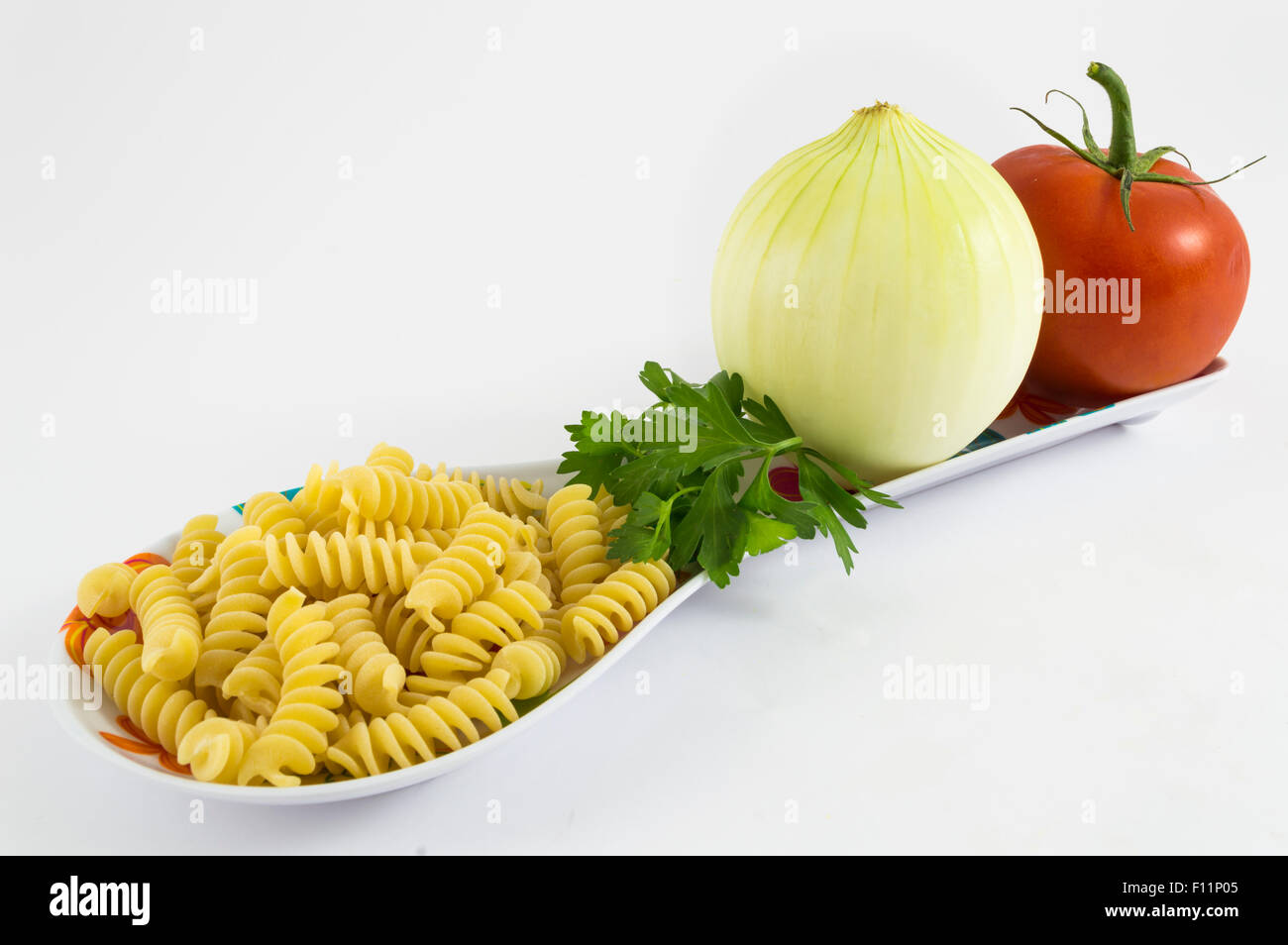 L'oignon, la tomate, le persil et les pâtes sur fond blanc Banque D'Images