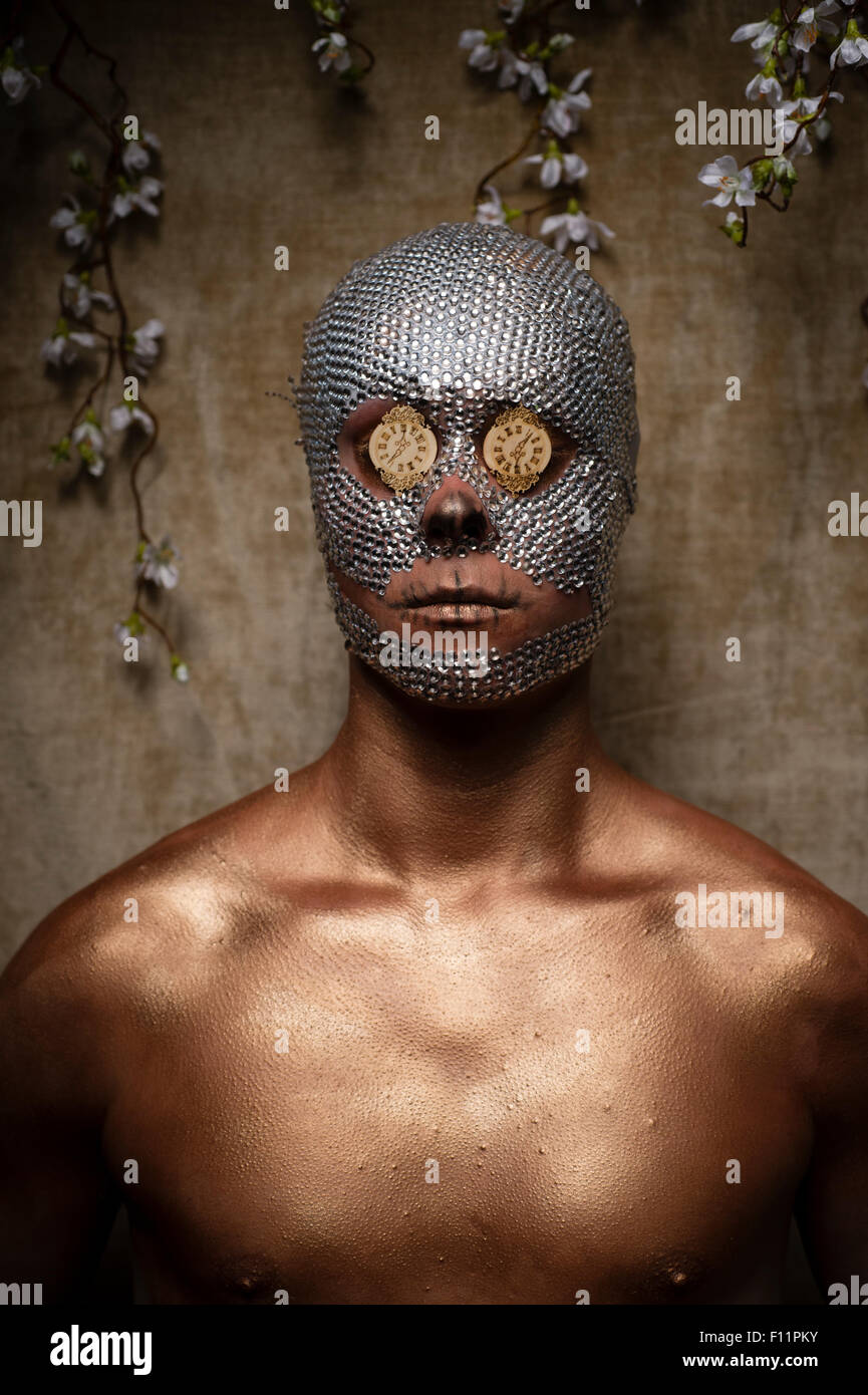 'Day of the Dead' thème portrait - un jeune homme avec des paillettes de cristal collé à son visage et mini réveil visages coincé sur ses yeux Banque D'Images
