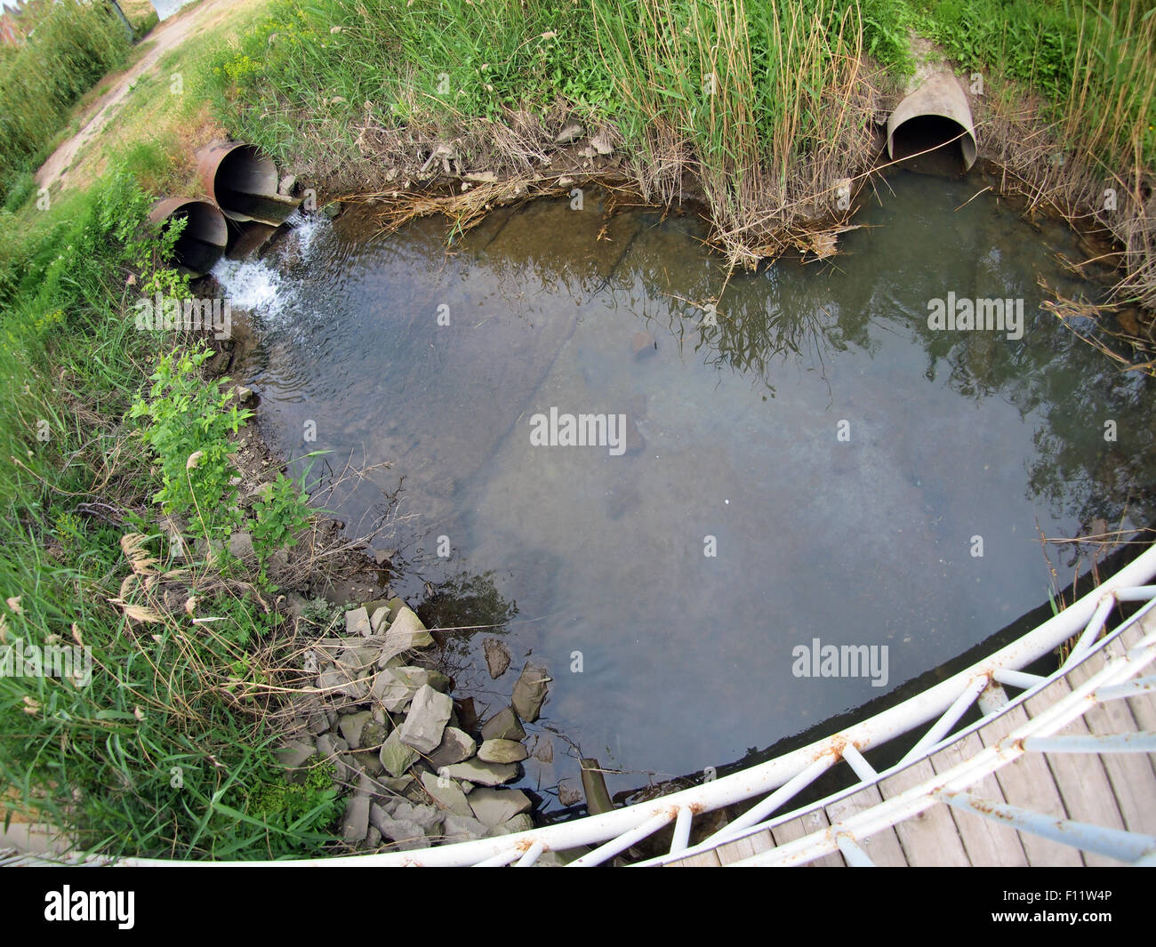 Mauvaise l'écologie : déchets souillés l'eau versée dans la rivière avec vue sur la distorsion grand angle Banque D'Images