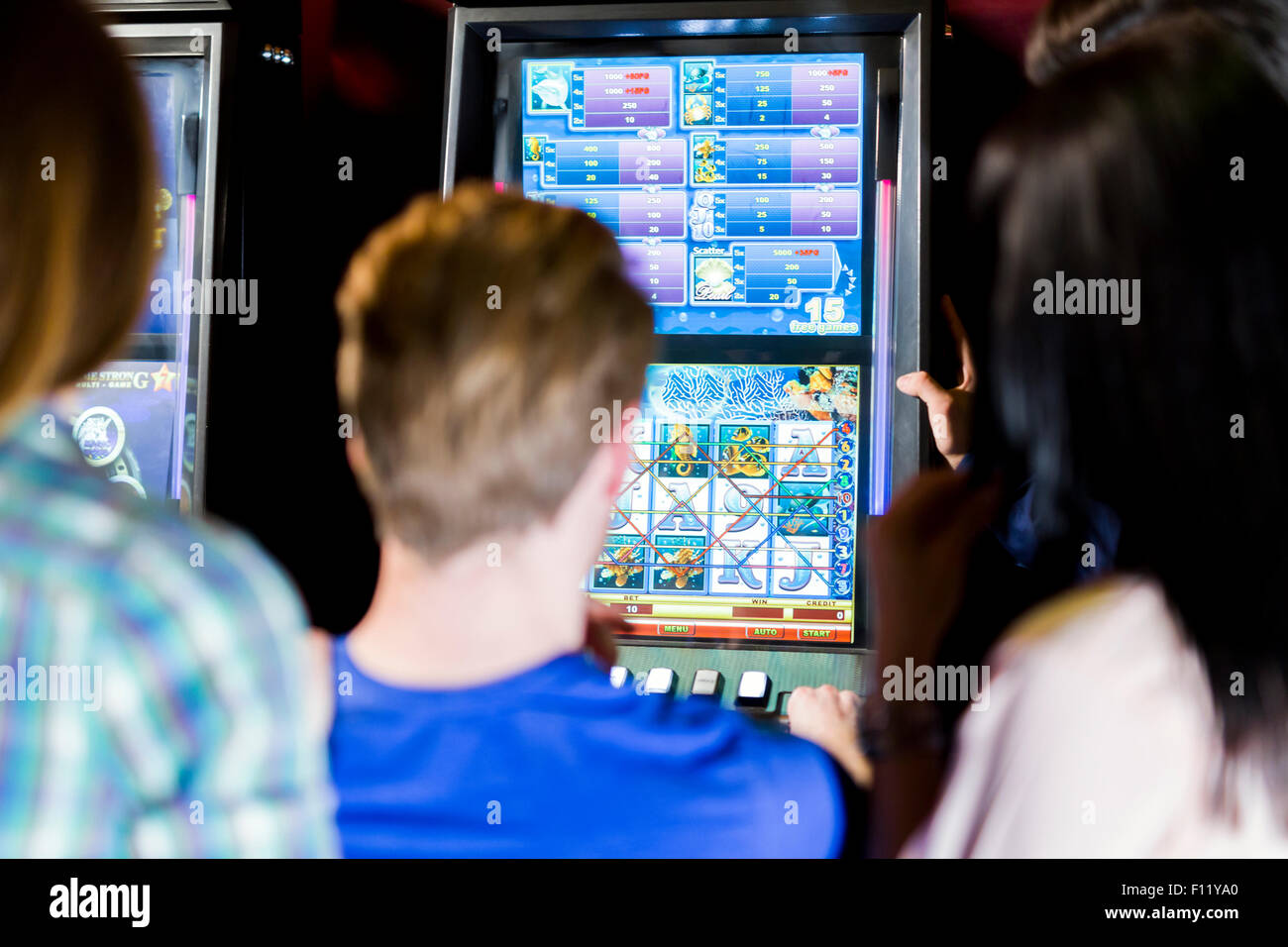 Jeune groupe de personnes jouant dans un casino jouer et diverses machines Banque D'Images