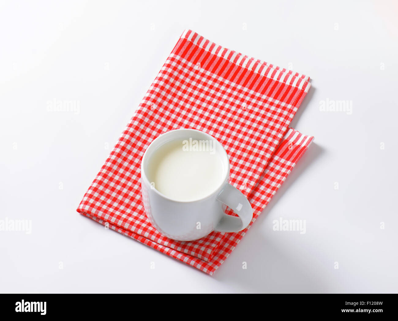 Tasse de lait dans le tissu à carreaux Banque D'Images