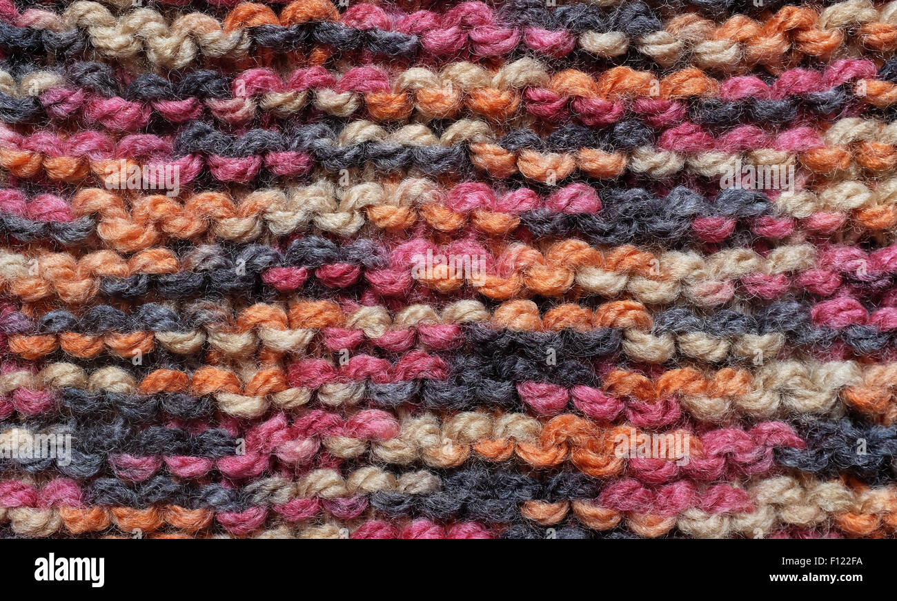 Close-up de lignes horizontales de garter stitch en rouge, noir, orange et marron laine comme une texture de fond abstrait Banque D'Images