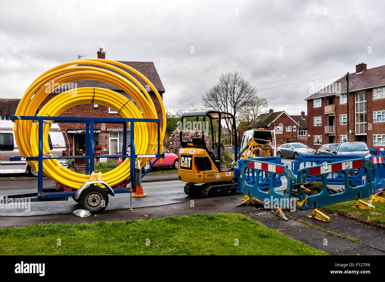 Deux gros rouleaux de tuyau de gaz haute pression jaune reste sur une remorque avant d'être utilisé pour remplacer un tube à propriétés domestiques Banque D'Images