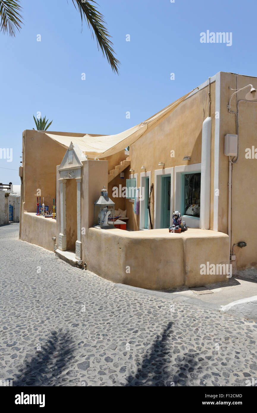 Un petit magasin dans une rue pavée dans un village de Santorin, Grèce. Banque D'Images