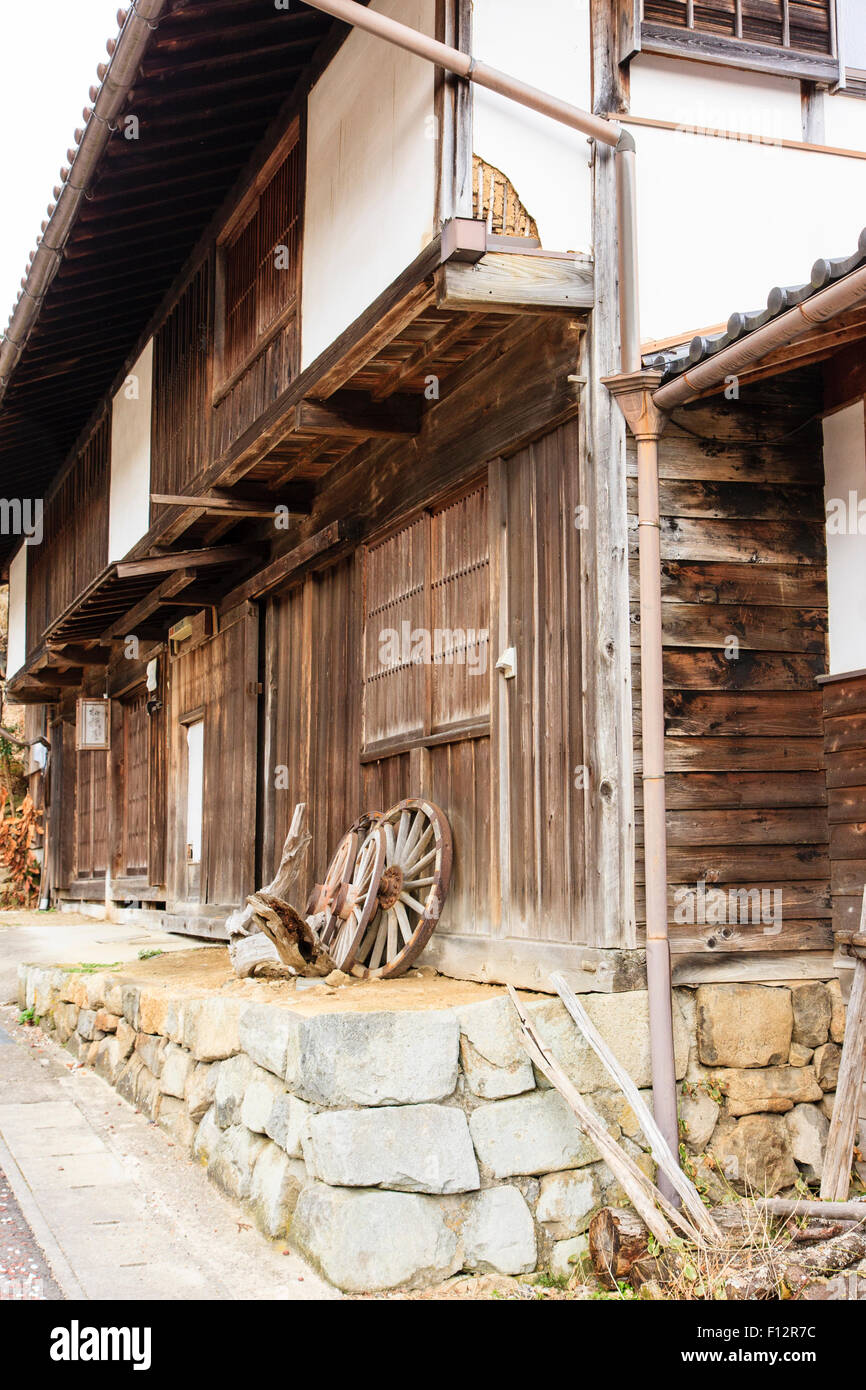 L'ancienne route Nakasendo. Les décideurs de roue chambre à Magome ville. Bois de la période Edo et de plâtre de deux étages, roues appuyée sur mur. Banque D'Images