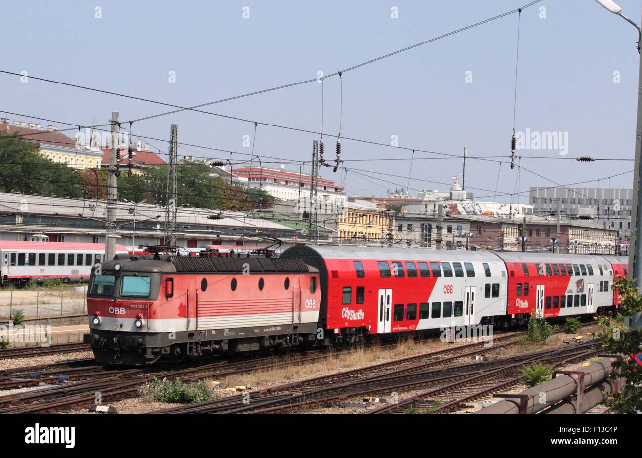 Locomotive électrique en livrée rouge OBB à l'avant du pont double city train quittant la gare Westbahnhof, Vienne, Autriche Banque D'Images