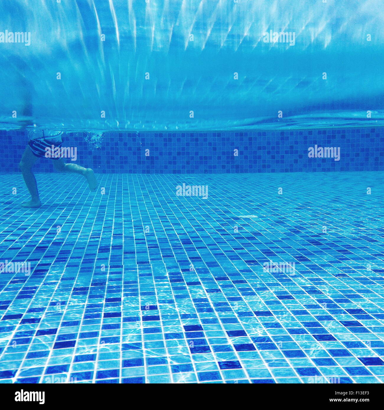 Vue sous-marine d'un boy walking in a swimming pool Banque D'Images