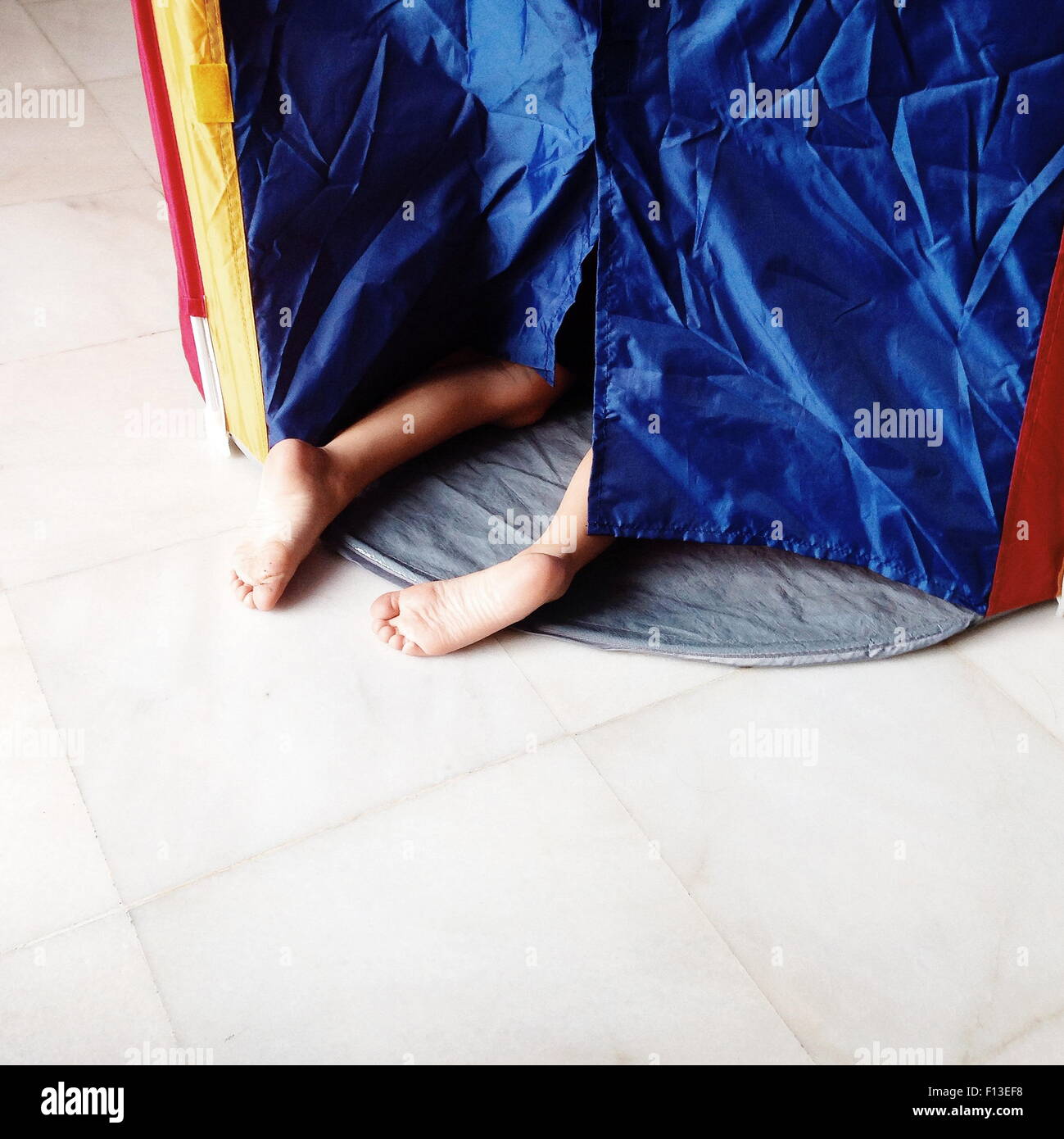 Garçon se faufiler dans une tente Banque D'Images