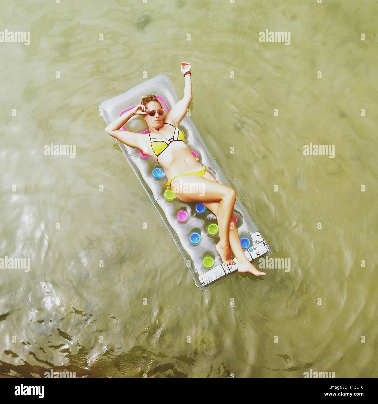 Vue aérienne d'une femme couchée sur un matelas gonflable dans la mer Banque D'Images