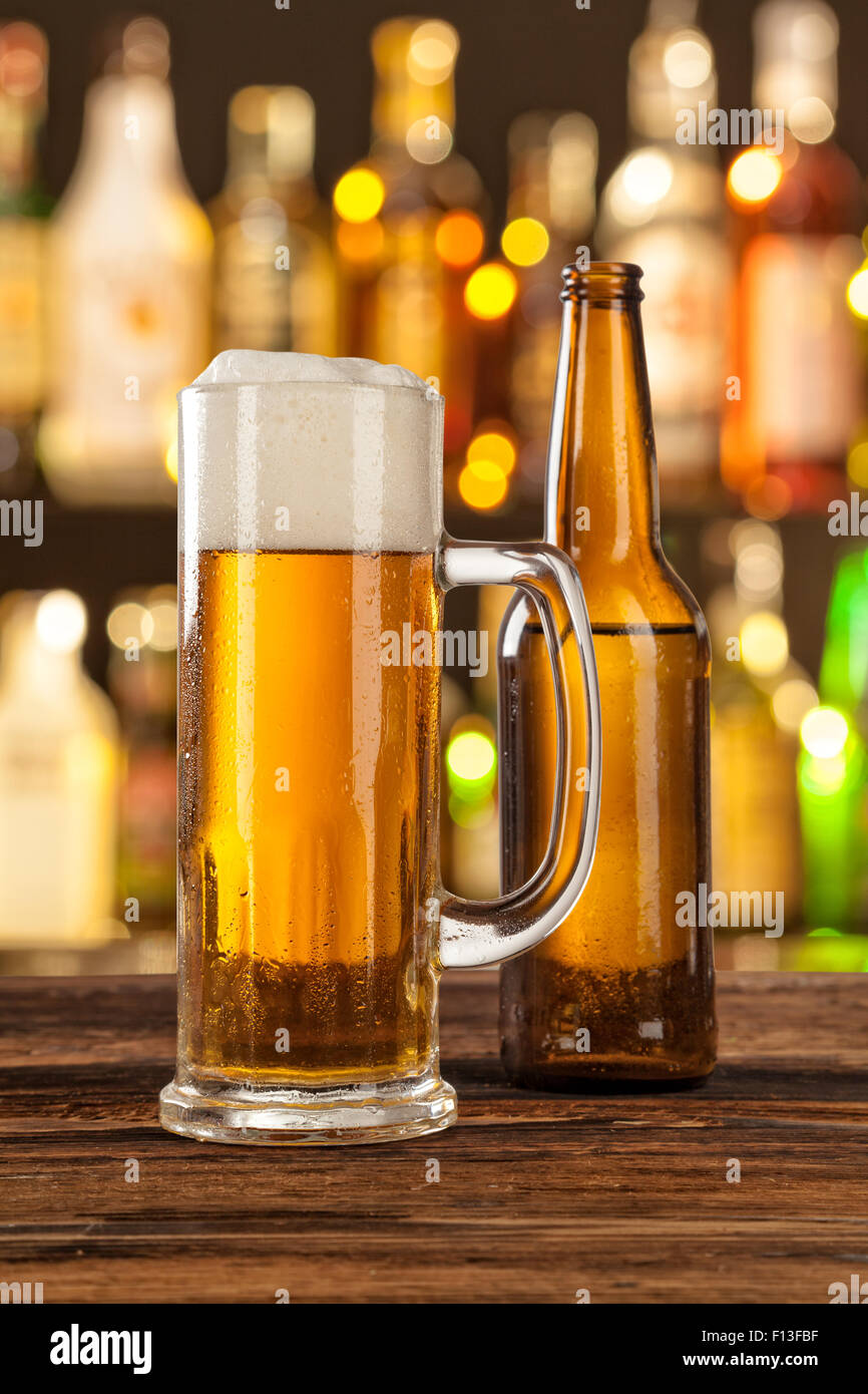 Verre de bière légère avec bar sur le contexte Banque D'Images