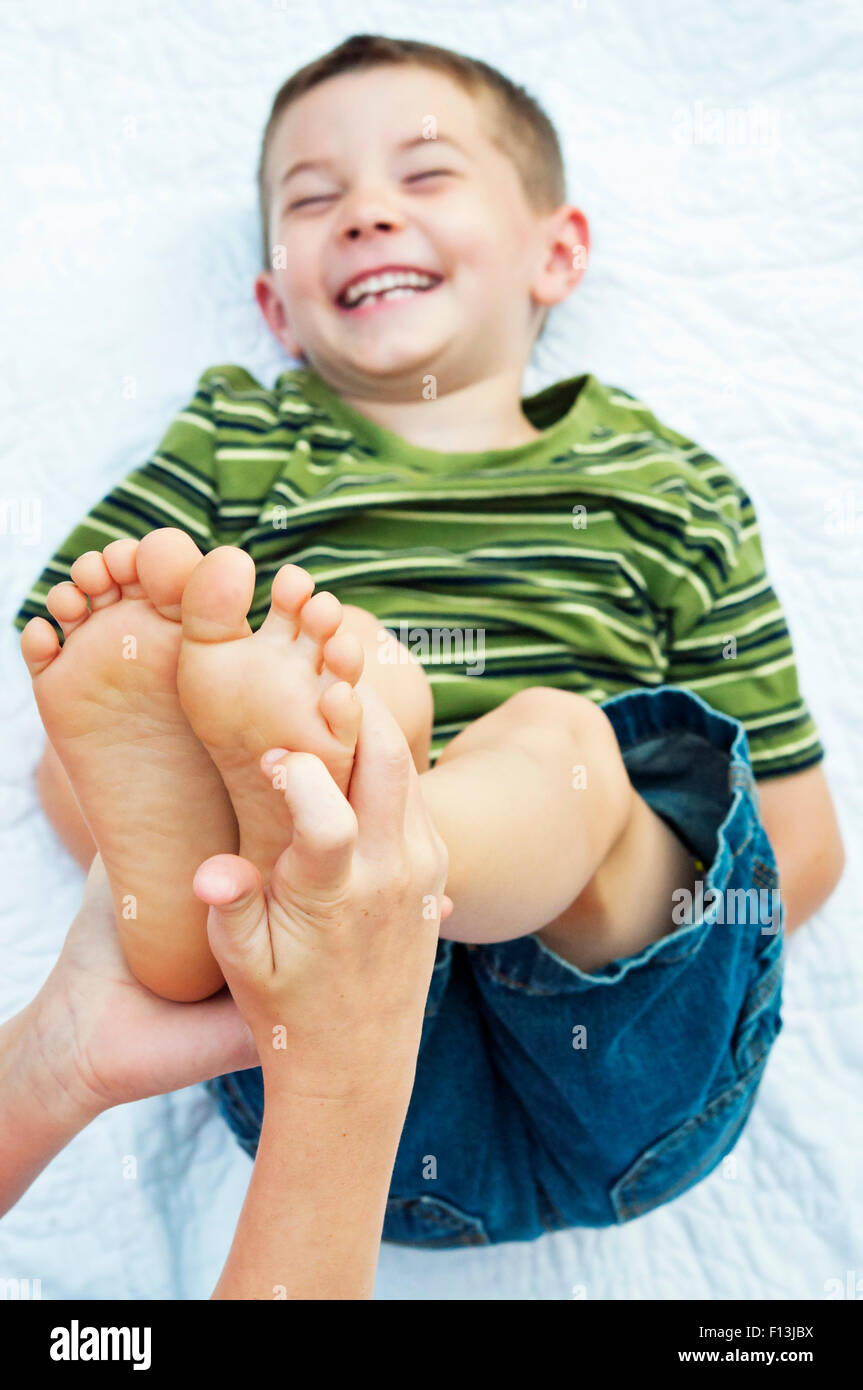Boy Getting ses pieds chatouillés Banque D'Images
