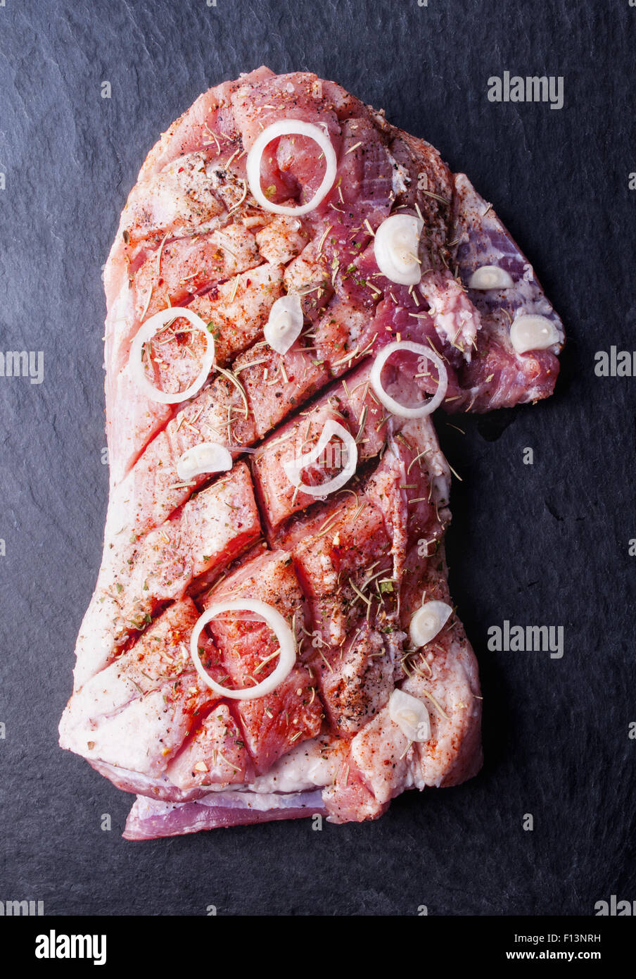 La viande de porc fraîche avec des épices sur fond noir en noir Banque D'Images La viande de porc fraîche avec des épices sur fond noir en noir Banque D'Images
