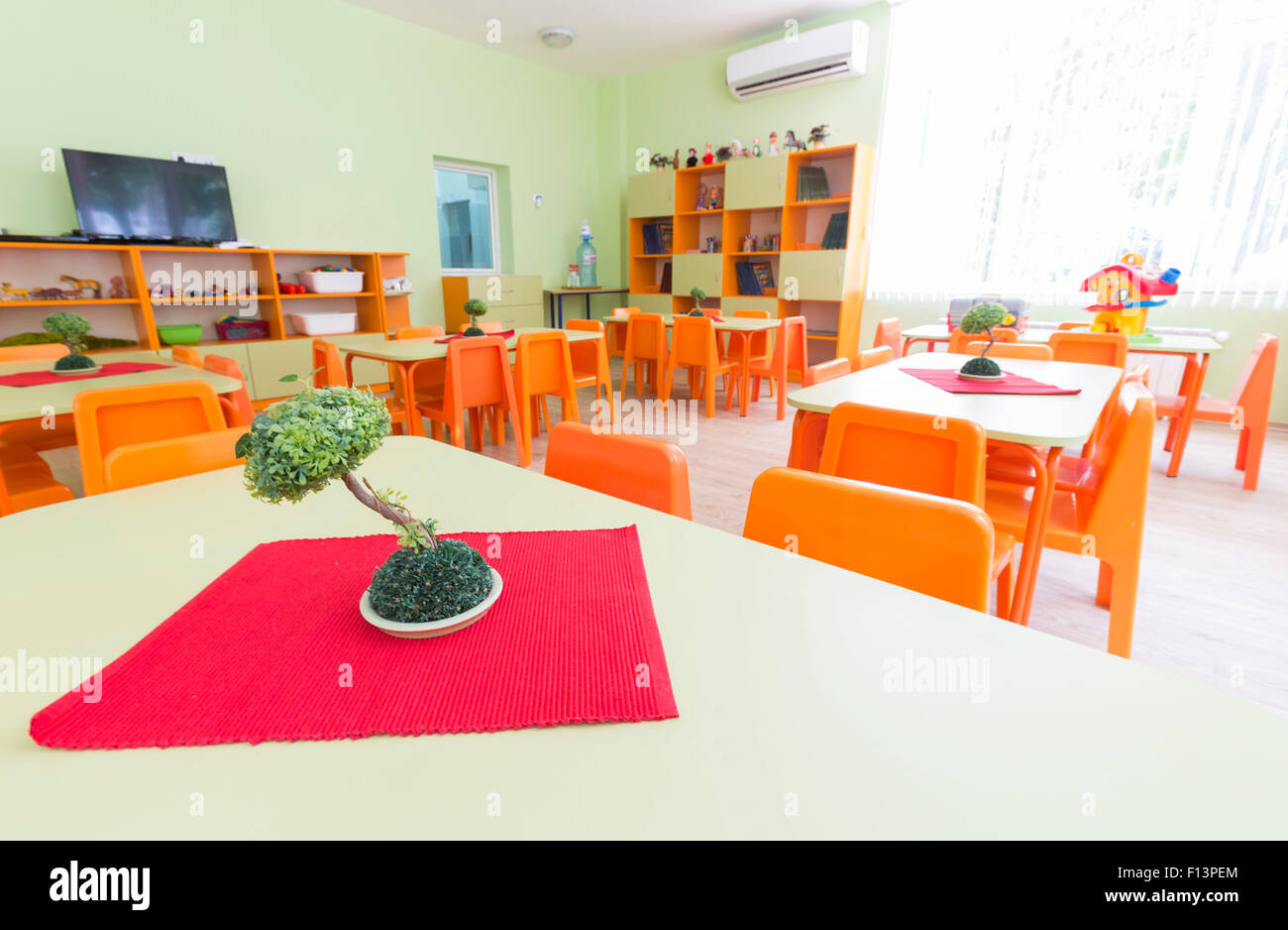 Classe de maternelle avec de petites tables et chaises pour les enfants. Banque D'Images